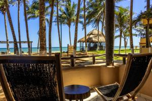 una mesa y sillas en la playa con palmeras en Reef Yucatán All Inclusive & Convention Center, en Telchac Puerto