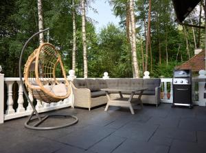a patio with a couch and a chair and a table at Slow Time in Morąg