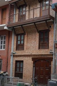 a brick building with a wooden door and a balcony at Studio Apartment at UNESCO Heritage Site in Kathmandu
