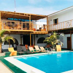a hotel with a swimming pool with chairs and a balcony at Hotel Viñas del Sol Eterno in Chincha Alta