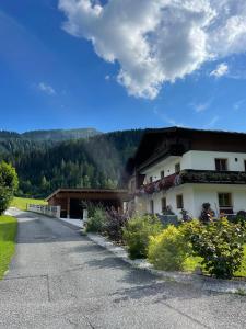 dom na drodze z górą w tle w obiekcie Ferienwohnungen Martlhof w mieście Leogang