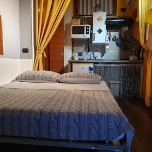 a bed in a room with a kitchen at Dora Baltea Monolocale primo piano Mansarda secondo piano in Verona