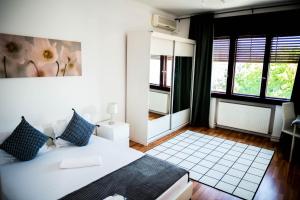 - une chambre avec un lit blanc et des oreillers bleus dans l'établissement CNC Apartments, à Bucarest