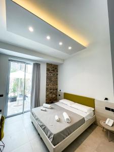 a bedroom with a large bed and a large window at MARINO WELLNESS in Alì Terme