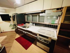 a small kitchen with a sink and a refrigerator at Sara in Kagoshima