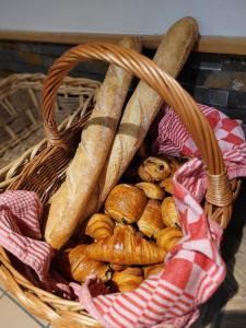 a basket filled with bread and pastries on a table at Résidence Julianna , trajets remontées mécaniques , livraison viennoiseries, piscine couverte in Morzine