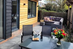 Un patio con una mesa y sillas y un sofá. en Het Zonnetje, en Wijk aan Zee