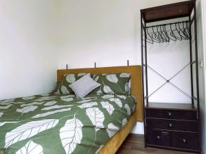 een slaapkamer met een bed en een dressoir met een spiegel bij Het Zonnetje in Wijk aan Zee