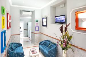 a living room with two chairs and a tv at Hotel Anfiteatro Flavio in Rome