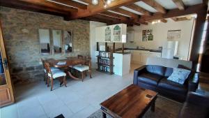 a living room with a couch and a table at Character 2 bed cottage within walking distance of bar/restaurants in Piégut-Pluviers