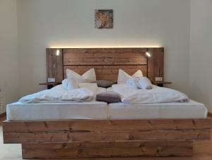 Schlafzimmer mit einem großen Bett mit einem Kopfteil aus Holz in der Unterkunft Ferien vom Ich in Neukirchen