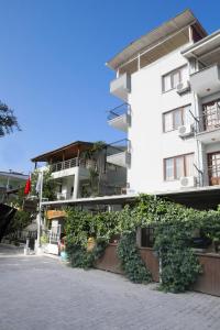 a white building with ivy growing up the side of it at İmaj Beach Hotel in İzmir