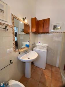 a bathroom with a sink and a toilet and a mirror at La Casa al Mare in Monopoli
