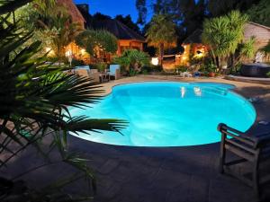 una piscina in un cortile posteriore di notte di B&B Lou Mas a Pommeret