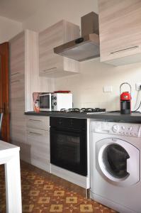 uma cozinha com um fogão e uma máquina de lavar roupa em VIALE REPUBBLICA 329 9 em Pietra Ligure
