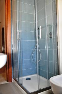 uma casa de banho com um chuveiro e uma porta de vidro em VIALE REPUBBLICA 329 9 em Pietra Ligure