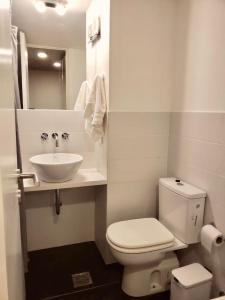 a bathroom with a white toilet and a sink at Departamento en Refinería Alto Rosario III in Rosario