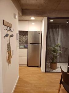 a kitchen with a stainless steel refrigerator in a room at Departamento en Refinería Alto Rosario III in Rosario