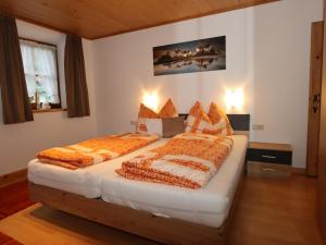 1 dormitorio con 2 camas y mantas anaranjadas y blancas en Beim Zuntl II, en Ehrwald 11 fotos más