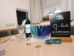 una botella de vino y un cartel en una mesa en Beim Zuntl II, en Ehrwald