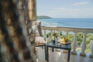 een balkon met een tafel met wijnglazen en uitzicht op de oceaan bij Vasilakis Home Fantasy Balcony Apraos in Apraos