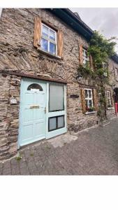 a stone building with a blue door and windows at Up Stairs Double Apartment Innishannon Mariners Rest in Cork