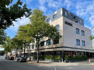 a building with a sign on the side of a street at STAYERY Wolfsburg City in Wolfsburg