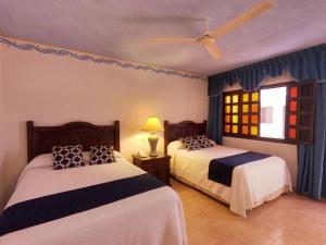 a bedroom with two beds and a window at Hotel Zaci in Valladolid