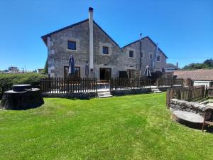 an old stone building with a fence and a yard at Character 2 bed cottage within walking distance of bar/restaurants in Piégut-Pluviers