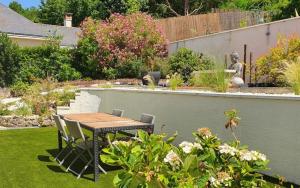 a table and chairs in a garden with a statue at Chambre de Charme dans maison d'hote "Le Petit Clouet" - Rochecorbon in Rochecorbon