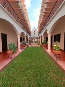 an empty courtyard of a building with a green lawn at Hotel Zaci in Valladolid