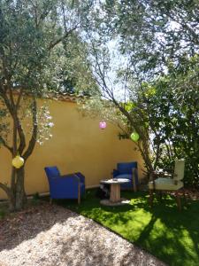 a yard with two chairs and a table and trees at STUDIO A 2 MN DE L A75 in Usclas-lʼHérault