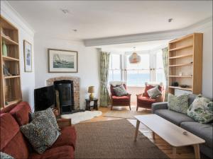 een woonkamer met een bank en een open haard bij Bell Cliff House in Lyme Regis