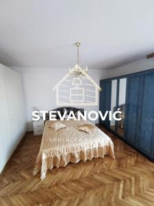 1 dormitorio con 1 cama y suelo de madera en Stevanovic Smestaj, en Vrnjci