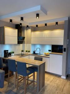 una cucina con un tavolo di legno e alcune sedie di Apartament Alan a Ustrzyki Dolne