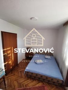a bedroom with a bed with a sign on the wall at Stevanovic Smestaj in Vrnjci