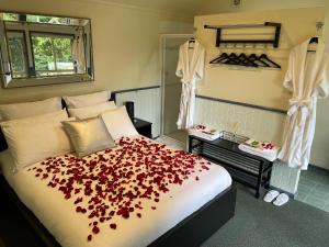 um quarto com uma cama com flores vermelhas em The Mountain View Cottage em The Patch