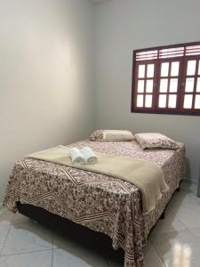 ein Schlafzimmer mit einem Bett mit zwei Handtüchern darauf in der Unterkunft Casa agradável no centro in Bananeiras
