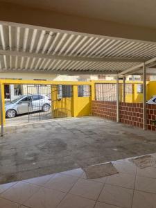 an empty parking lot with a yellow wall at Casa agradável no centro in Bananeiras