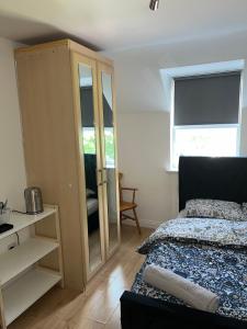 1 dormitorio con 1 cama, armario y ventana en The Court en Stone Grove