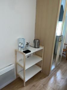 a small white shelf with a sink and a mirror at The Court in Stone Grove