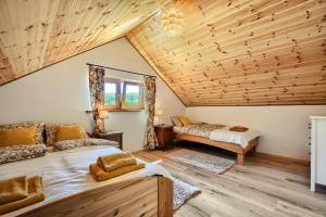 - une chambre avec deux lits et un plafond en bois dans l'établissement Na widoku- domki Bukowiec, à Bukowiec