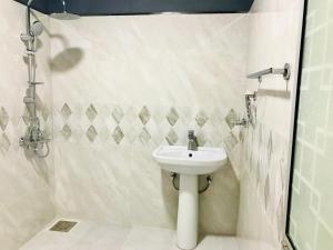 biała łazienka z umywalką i prysznicem w obiekcie Beach Bungalow Yala w mieście Kirinda