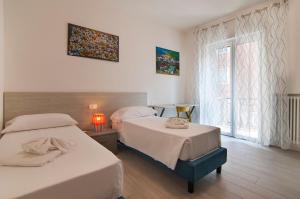 a bedroom with two beds and a window at Dimore Verona in Verona