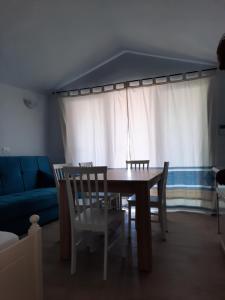 a dining room with a table and chairs and a couch at Relax al Mare in Olbia