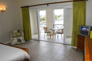 a bedroom with a bed and a television and a balcony at The Bliss in Gros Islet