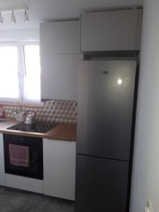 cocina con nevera negra y fregadero en Apartament Gdańsk Stogi Plaża, en Gdansk