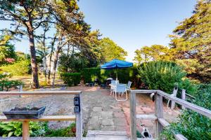 une terrasse avec un parasol, une table et des chaises dans l'établissement SeaWind Guest Studio, à Nauset Heights