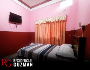 ein Schlafzimmer mit einem Bett und einem TV an der Wand in der Unterkunft Residencial Guzmán 1 in Yacuiba