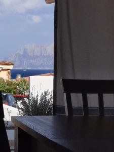 una silla sentada en un balcón con vistas al océano en Relax al Mare, en Olbia